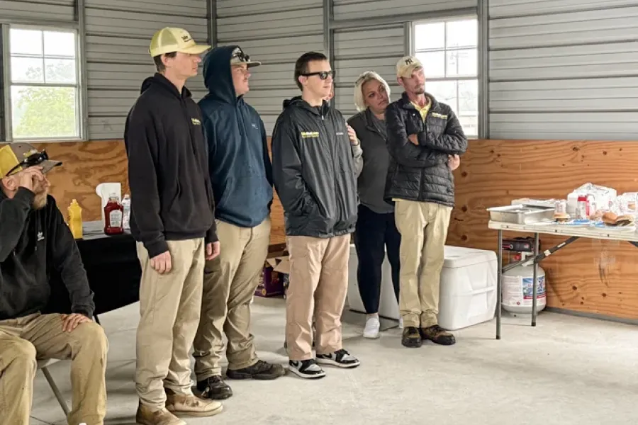 Tailor Made Lawns team members standing together at a company BBQ